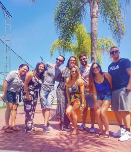 foto de amigos reunidos em frente a um coqueiro