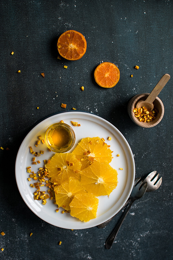 foto de um prato com laranjas num fundo preto