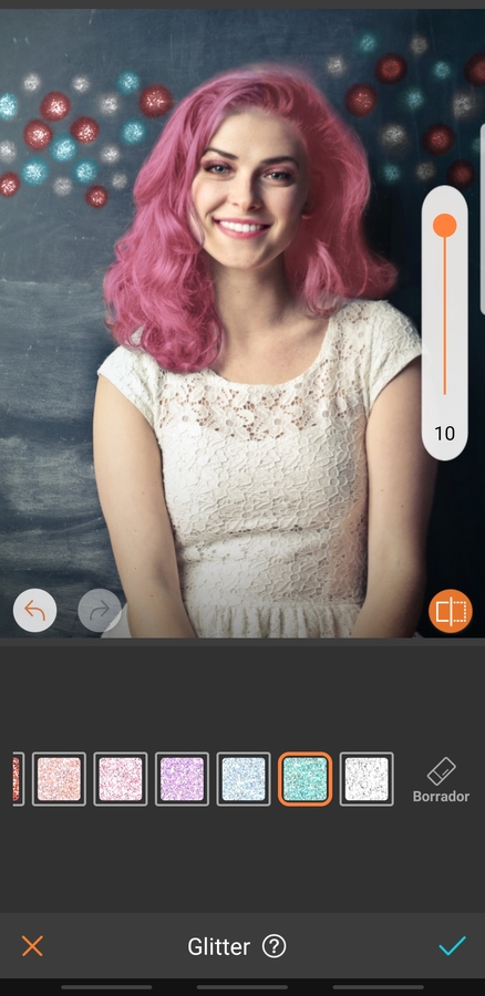 retrato de mujer sonriendo, con maquillaje llamativo y cabello rosa