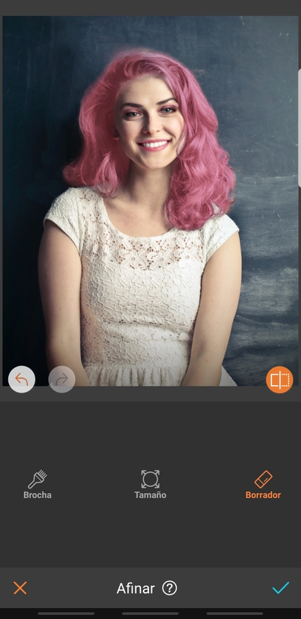 retrato de mujer sonriendo, con maquillaje llamativo y cabello rosa