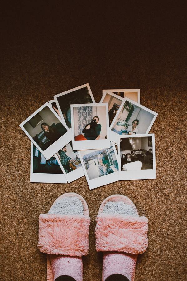 fotografías instantáneas estilo polaroid en el piso junto a unos pies