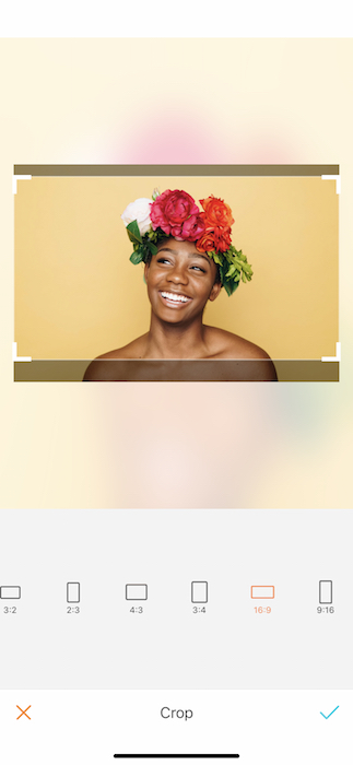Picture of bald black woman with a crown of flowers being edited by AirBrush with the Crop Tool