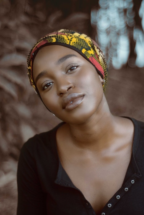 African woman wearing a black top and head tie