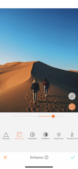 two women walking on a sand dune