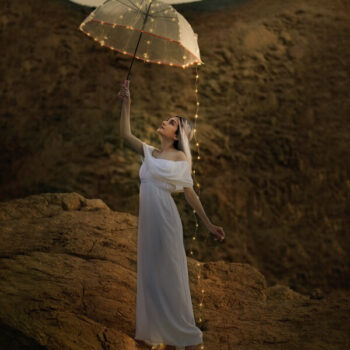 mujer con vestido blanco y paraguas transparente