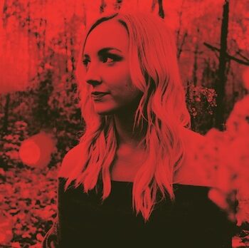 Picture of a blonde girl in the forest with red filter