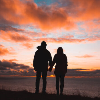 Picture of a couple holding hands during the sunset