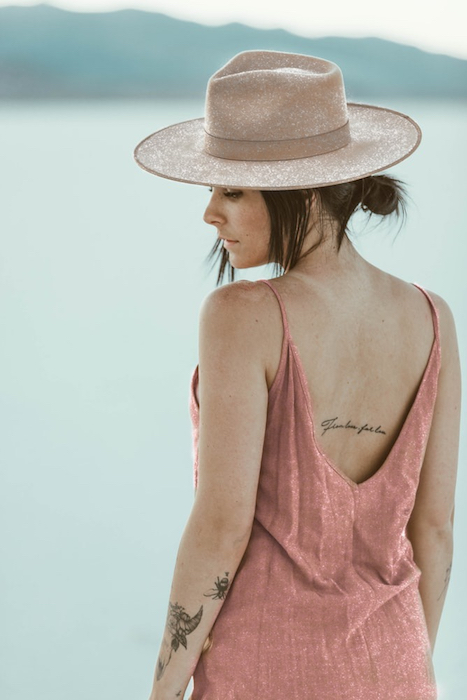 woman with tattoos in glittery hat and pink dress