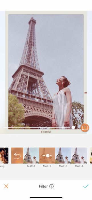 vintage photo of white woman standing in front of the Eiffel Tower