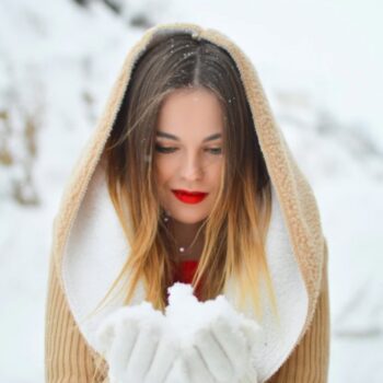 mujer rubia en la nieve, con labios rojos