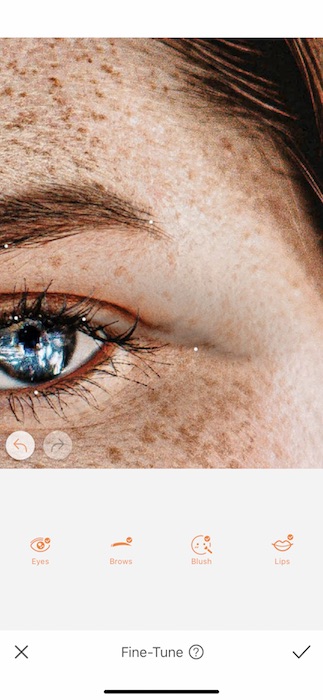 Picture of a white woman with freckles being edited by AirBrush with Fine-tune tool