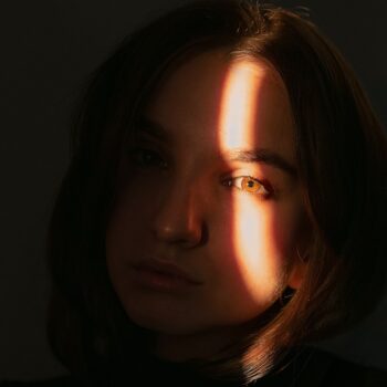 foto oscura de mujer con rayo de luz sobre la cara