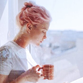 Picture of a white woman with pink hair drinking tea