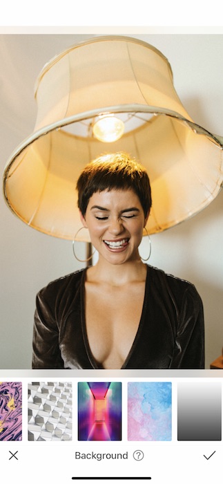 woman with a pixie haircut making a silly face while sitting under a lamp