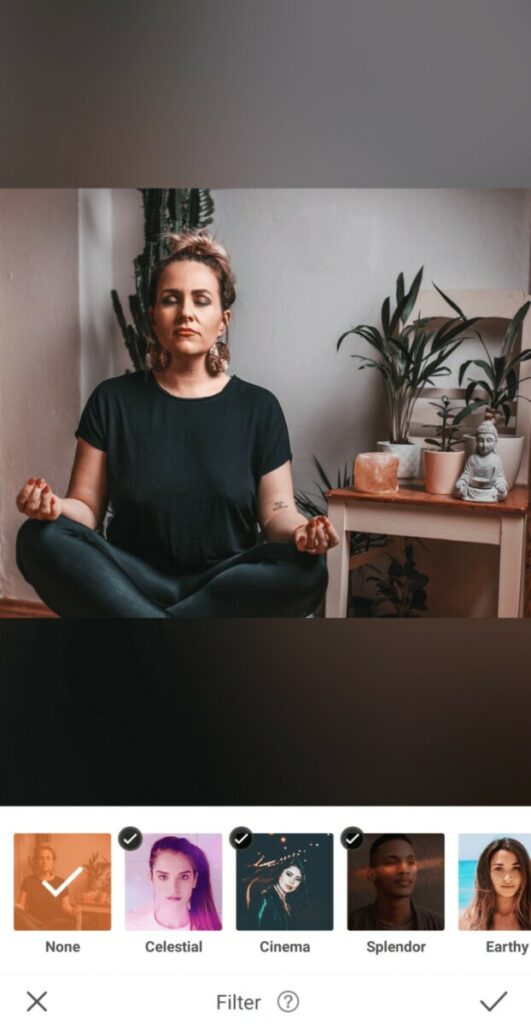 woman sitting and meditating next to plants