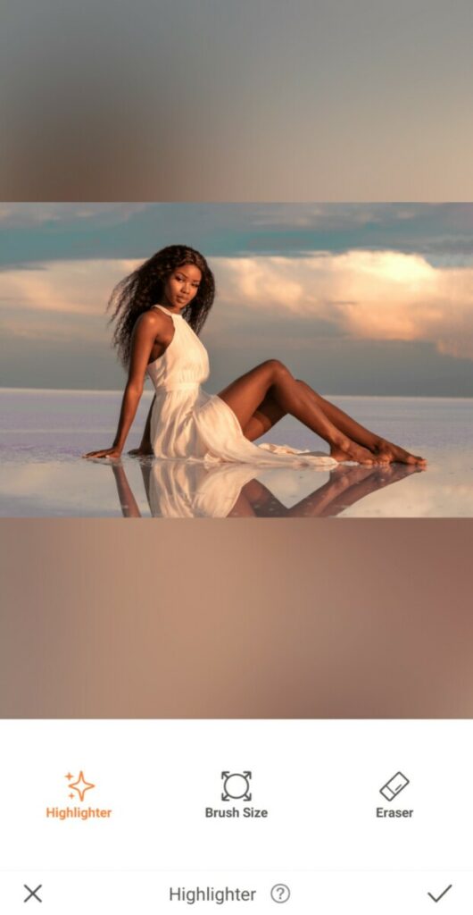 International Day of Tropics edit featuring woman in a white dress sitting in water against a sunset sky