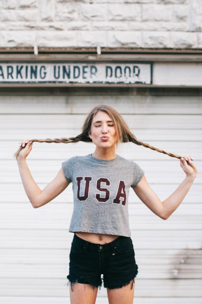 woman with blonde pigtails wearing grey USA t-shirt and black shorts 