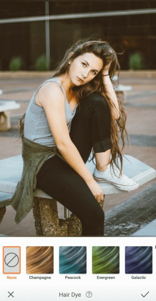 woman with brown hair wearing grey tank top and black jeans
