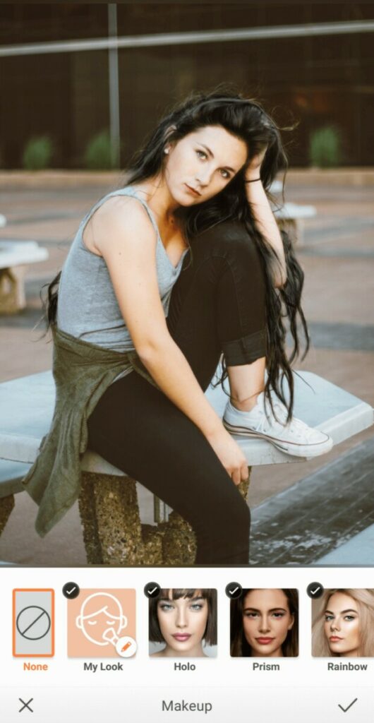 woman with black hair wearing grey tank top and black jeans