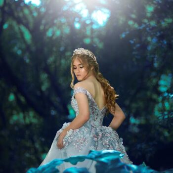 Uma mulher na floresta com um vestido azul de princesa, igual da Cinderella