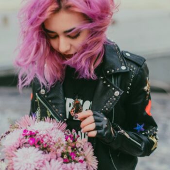 mujer rockera con cabello rosa y chamarra de cuero negra
