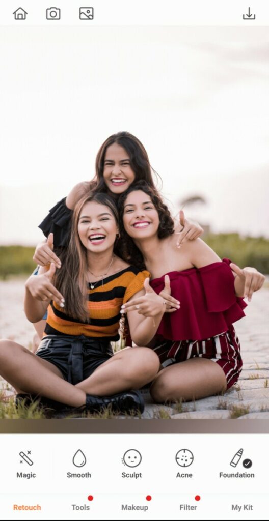 Group Photo of three smiling women taking a photo on the beach