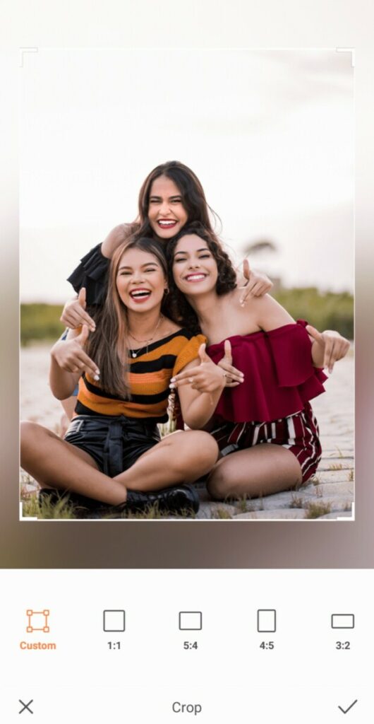 Group photo of three smiling women taking a photo on the beach
