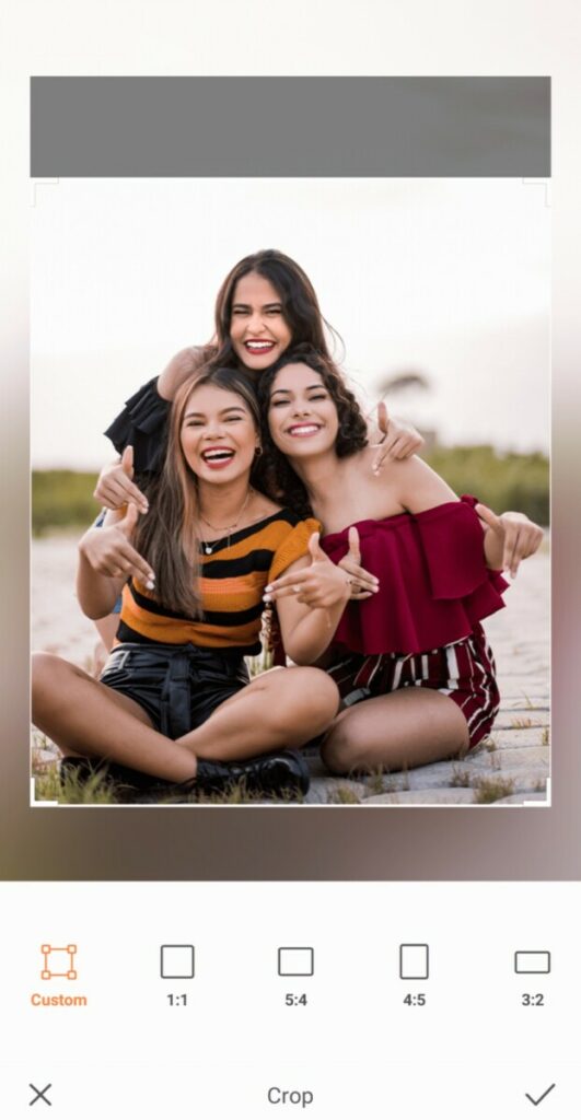 three smiling women taking a photo on the beach