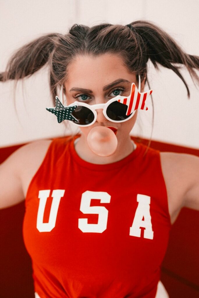 woman wearing July 4th outfit with stars and stripes sunglasses and USA shirt