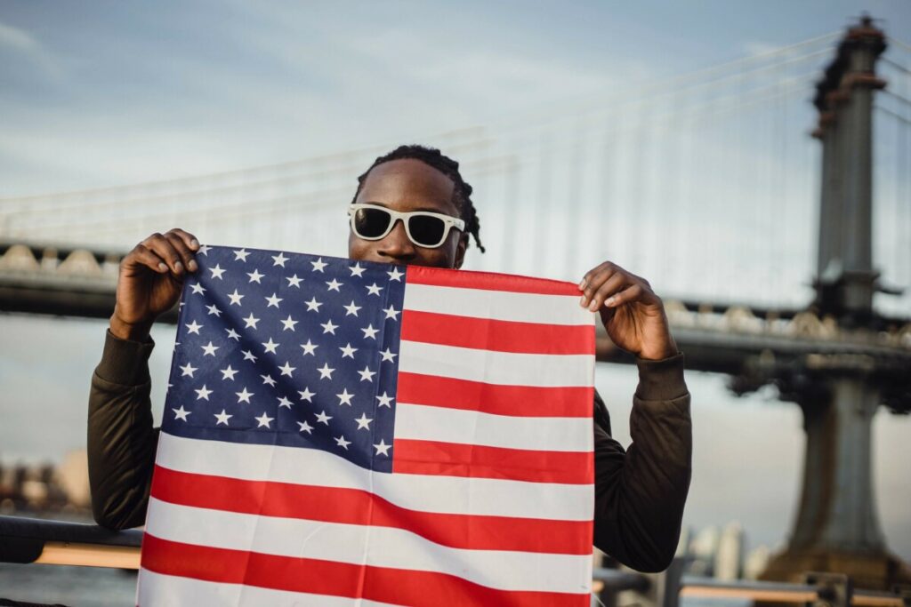 man holds up American flag on July 4th