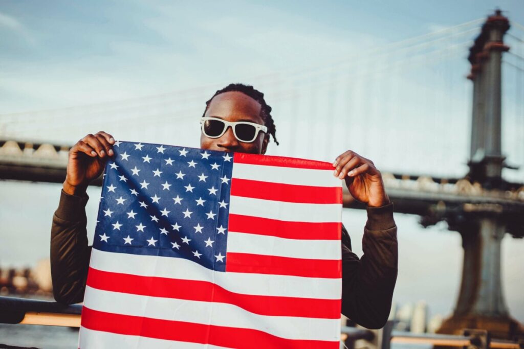 man holds up American flag on July 4th - Edited