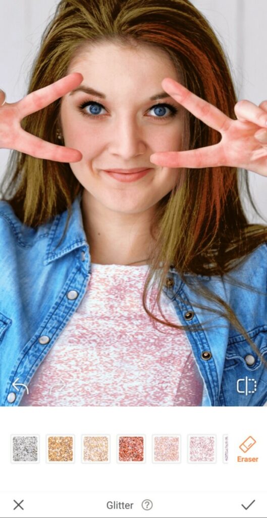 woman wearing chambray shirt making the peace sign over her eyes