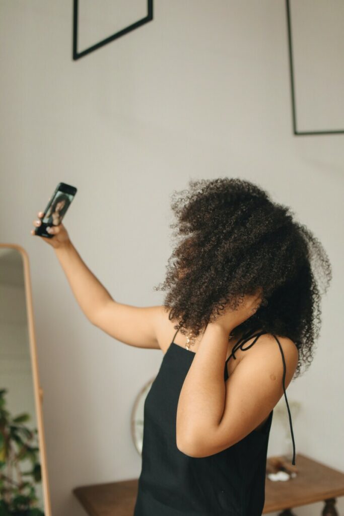 woman with curly hair takes a selfie