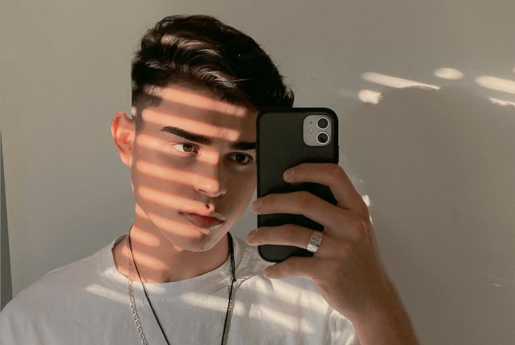 man takes a selfie in the shadows