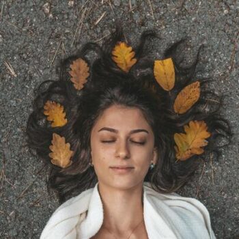 mulher deitada com folhas no cabelo