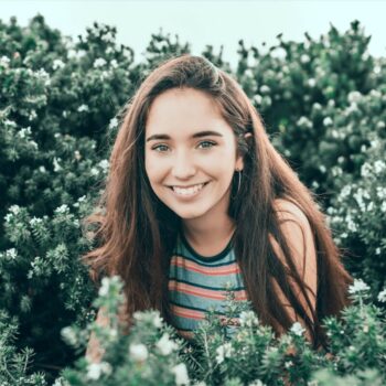 smiling girl surrounded by greenery