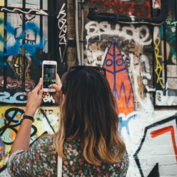 woman taking a photo of graffiti