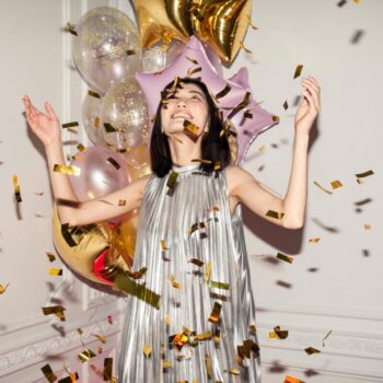 woman celebrating with confetti and balloons