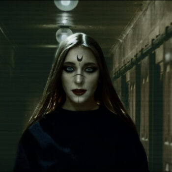 woman wearing witch makeup standing in a dark hallway