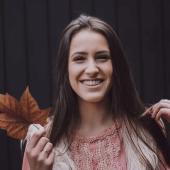 woman holding an autumn leaf
