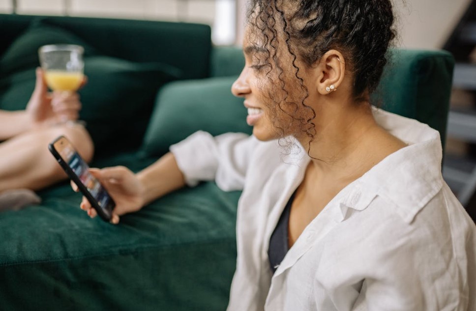 woman smiling while using her cell phone