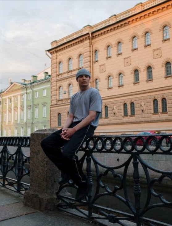 man sitting on bridge railing