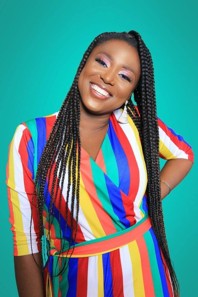foto de uma mulher negra posando com roupas coloridas e sorrindo